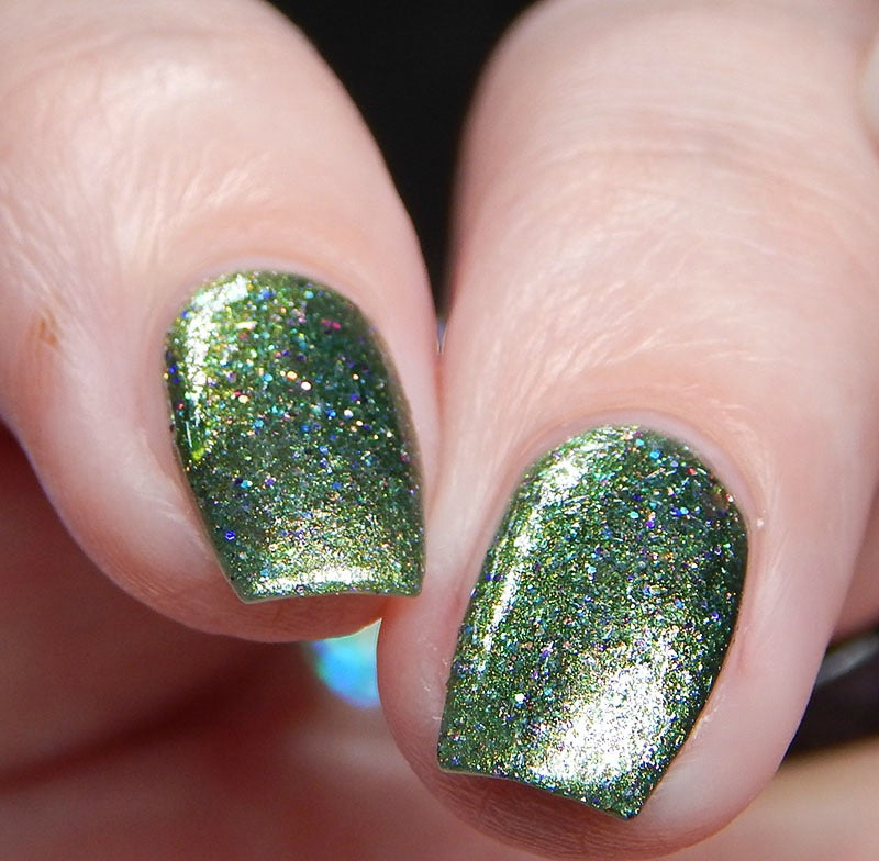 Close-up of fingers showcasing "Phasers on Stun.078," a metallic deep green polish with a glittery, holographic finish by PI Colors.