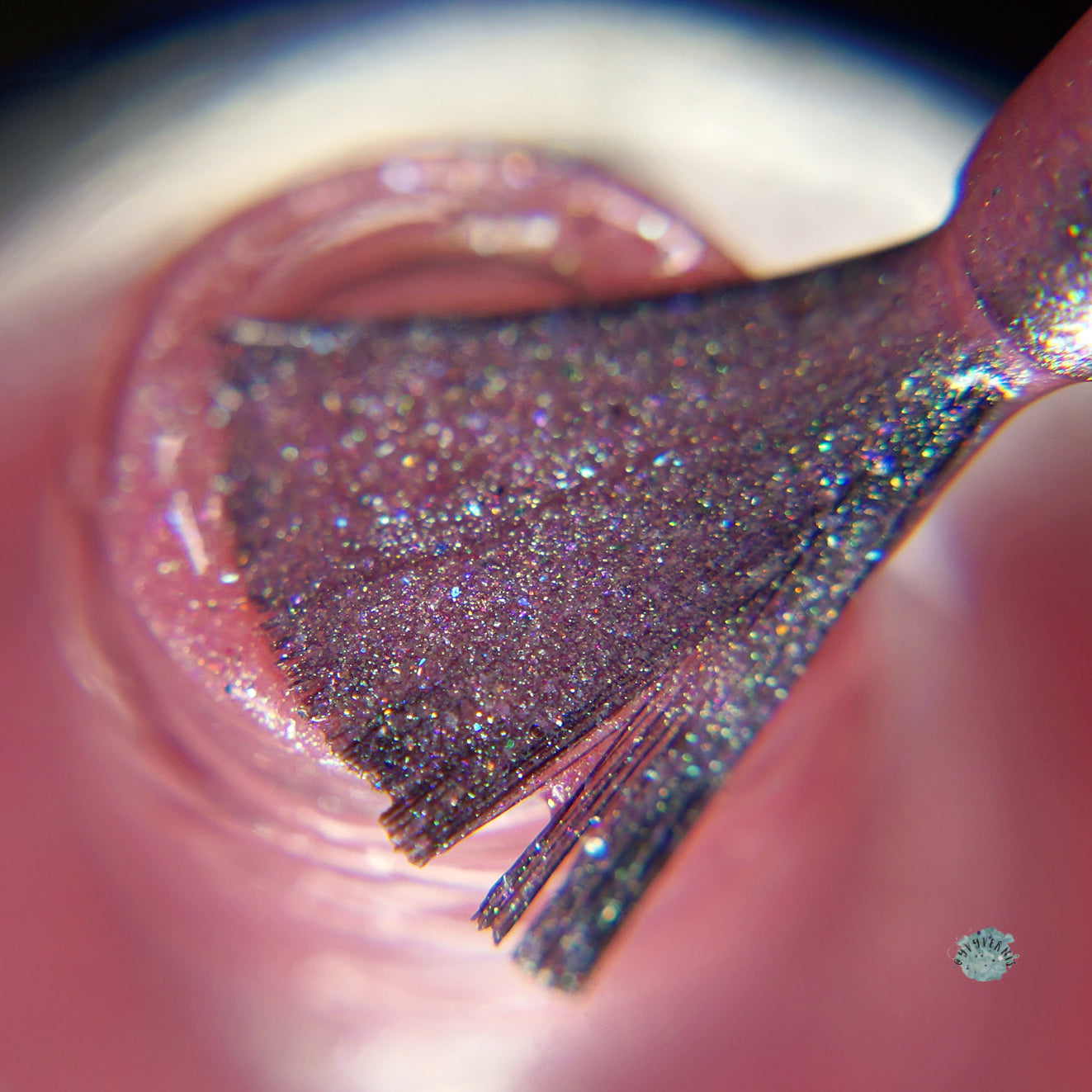 A close-up shot showcases the brush of PI Colors' Roseate Bliss.012 Pink Nail Polish applying a shimmering pink hue with holographic glitters. The brush is generously coated with the dazzling 10-free formula, and the bottle's opening is visible beneath it.