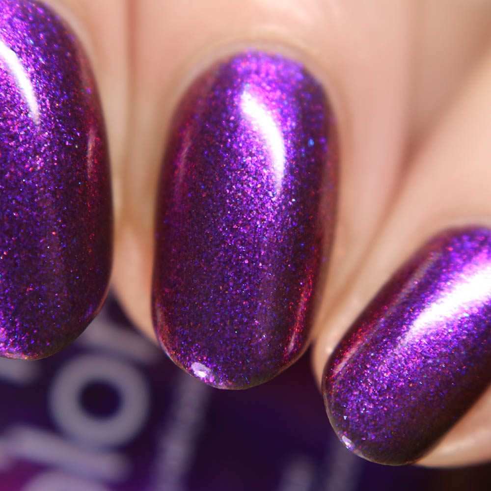 Close-up of fingers with glossy, metallic purple multichrome nail polish named Danbury Does It.000 by PI Colors, showcasing a sparkling finish that highlights the vibrant color and smooth texture.