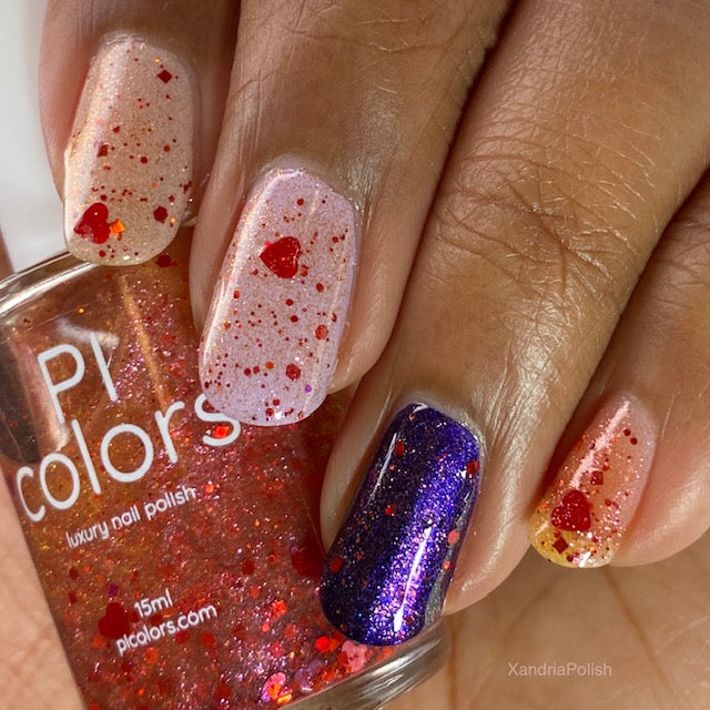 A close-up of a hand displays nails decorated with two nail polishes. Three nails are adorned with PI Colors' Strawberry Heart.208 Red Nail Polish Topper, featuring a clear base with red glitter and holographic heart shapes, while another nail is painted in a glittery dark purple. The bottle labeled "PI Colors Luxury Nail Polish" shows off its 10-free formula next to the stunning arrangement.