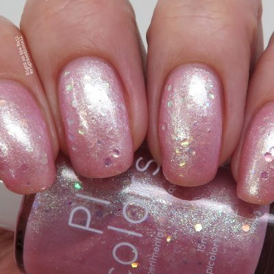 A close-up of a hand highlights pastel pink jelly nail polish accented with iridescent glitter. The nails feature a glossy finish, and below them is the PI Colors bottle labeled Pink Candy.210, perfectly mirroring the nail color and effect.