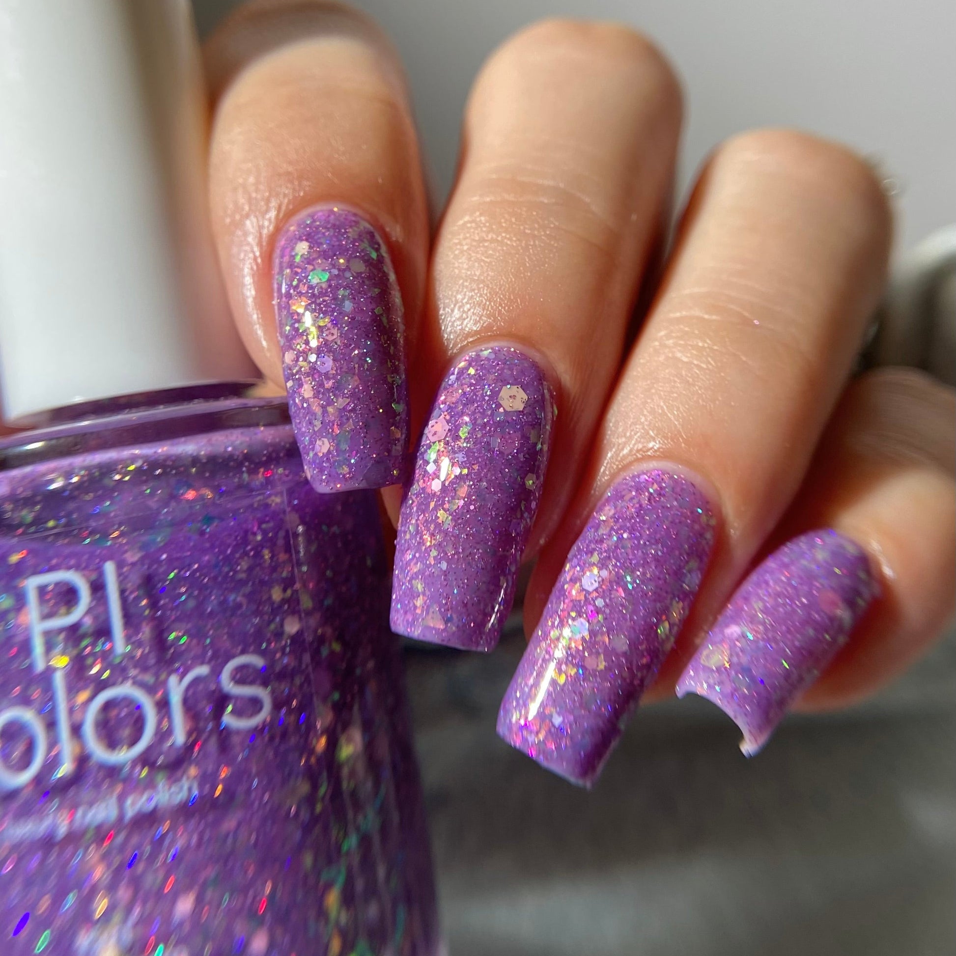 Purple nail polish with iridescent rainbow flakies and holo glitter by PI Colors