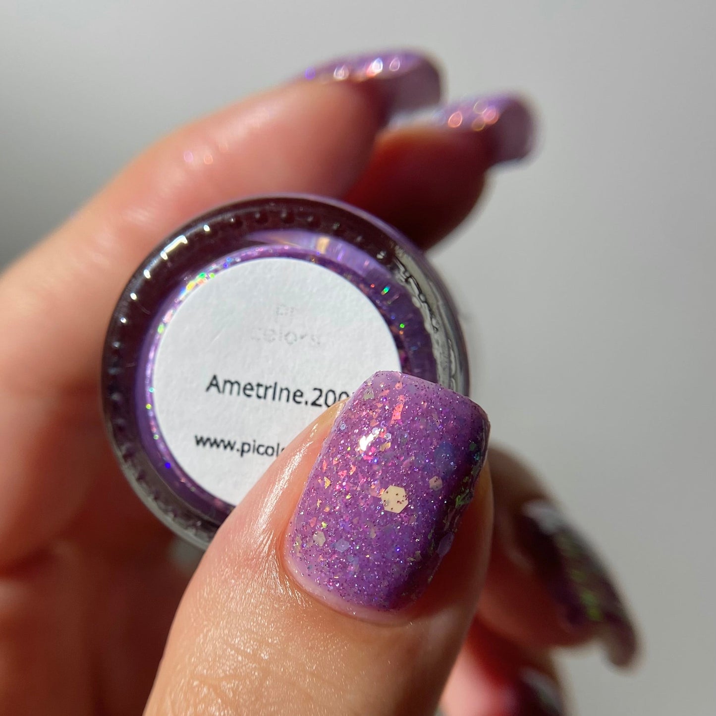Purple nail polish with iridescent rainbow flakies and holo glitter by PI Colors