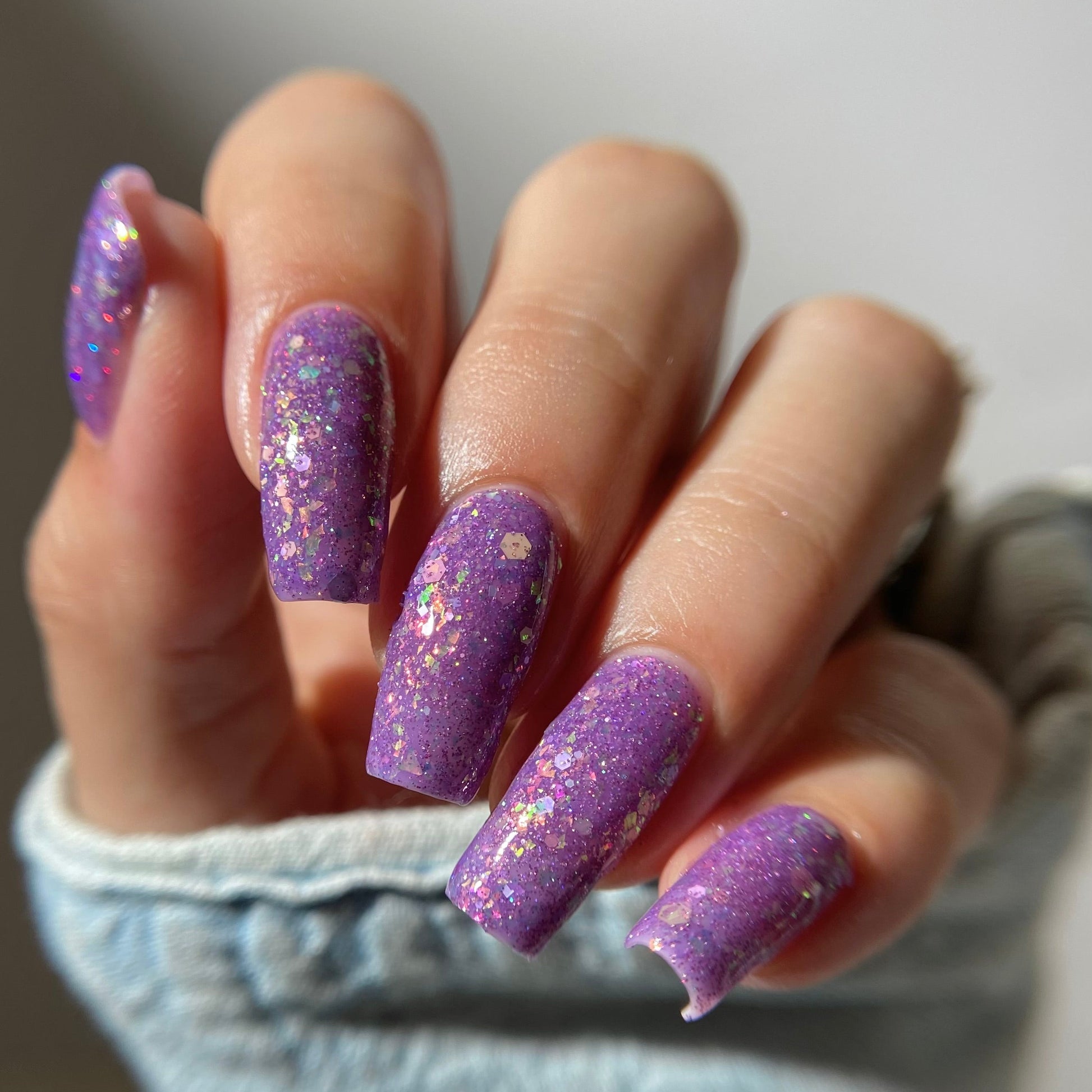 Purple nail polish with iridescent rainbow flakies and holo glitter by PI Colors