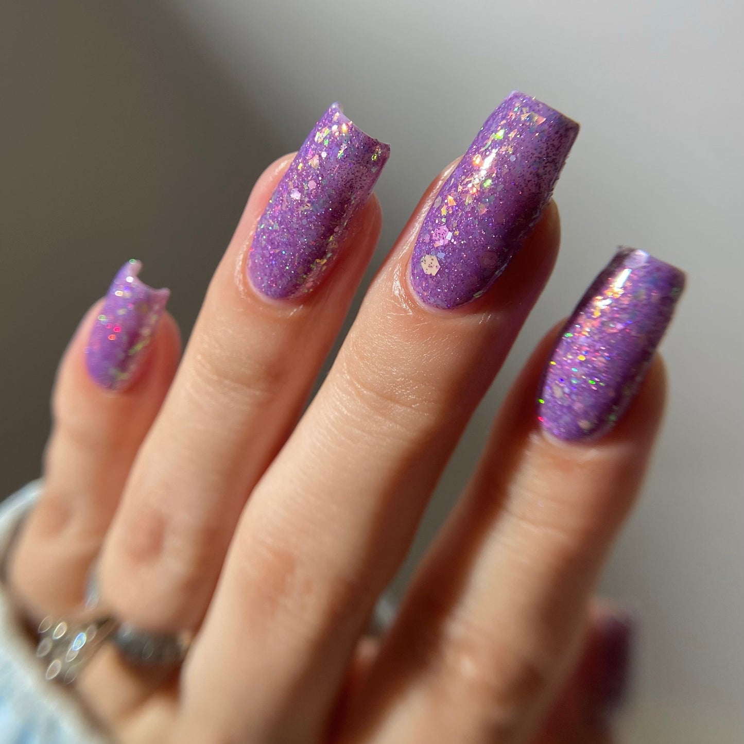 Purple nail polish with iridescent rainbow flakies and holo glitter by PI Colors
