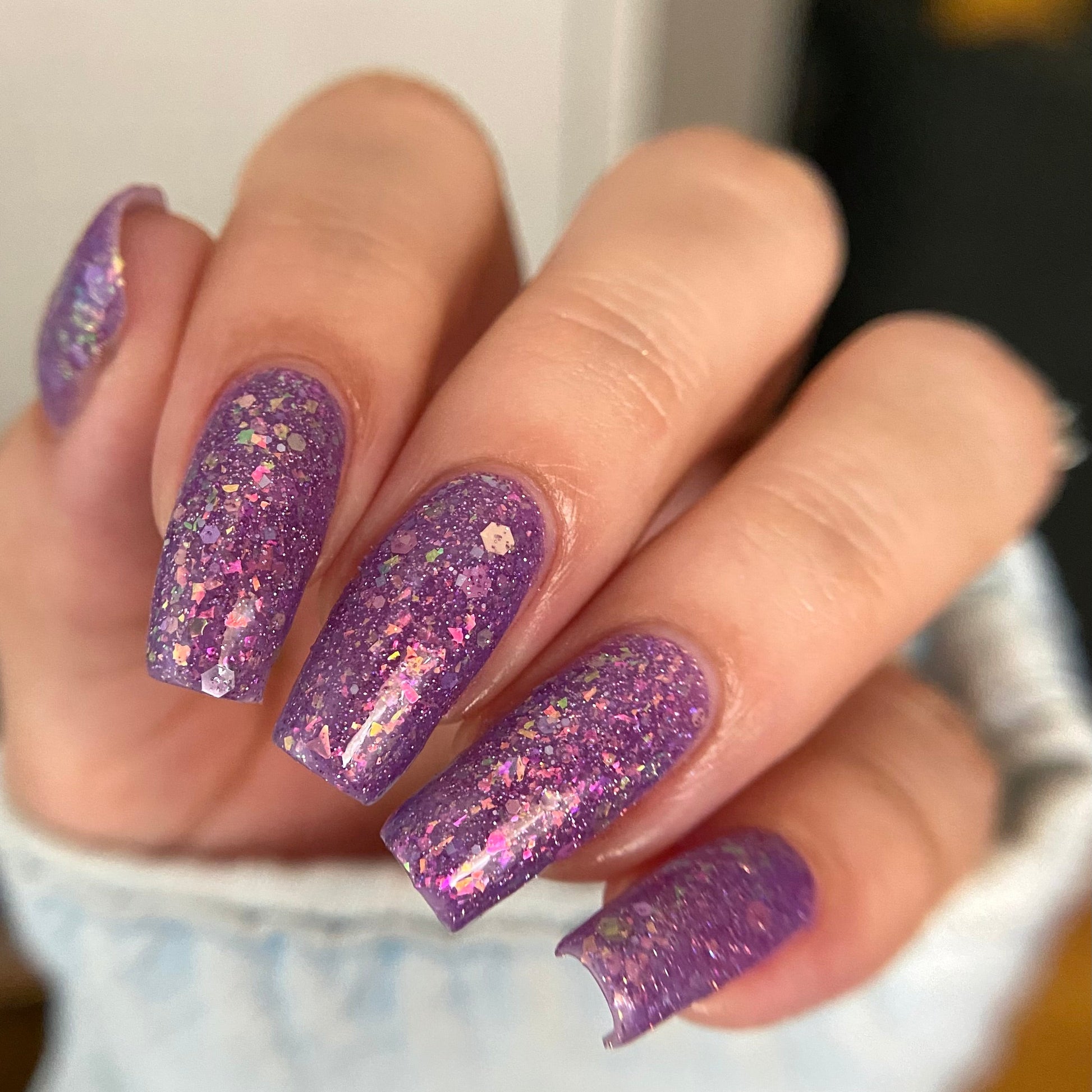 Purple nail polish with iridescent rainbow flakies and holo glitter by PI Colors