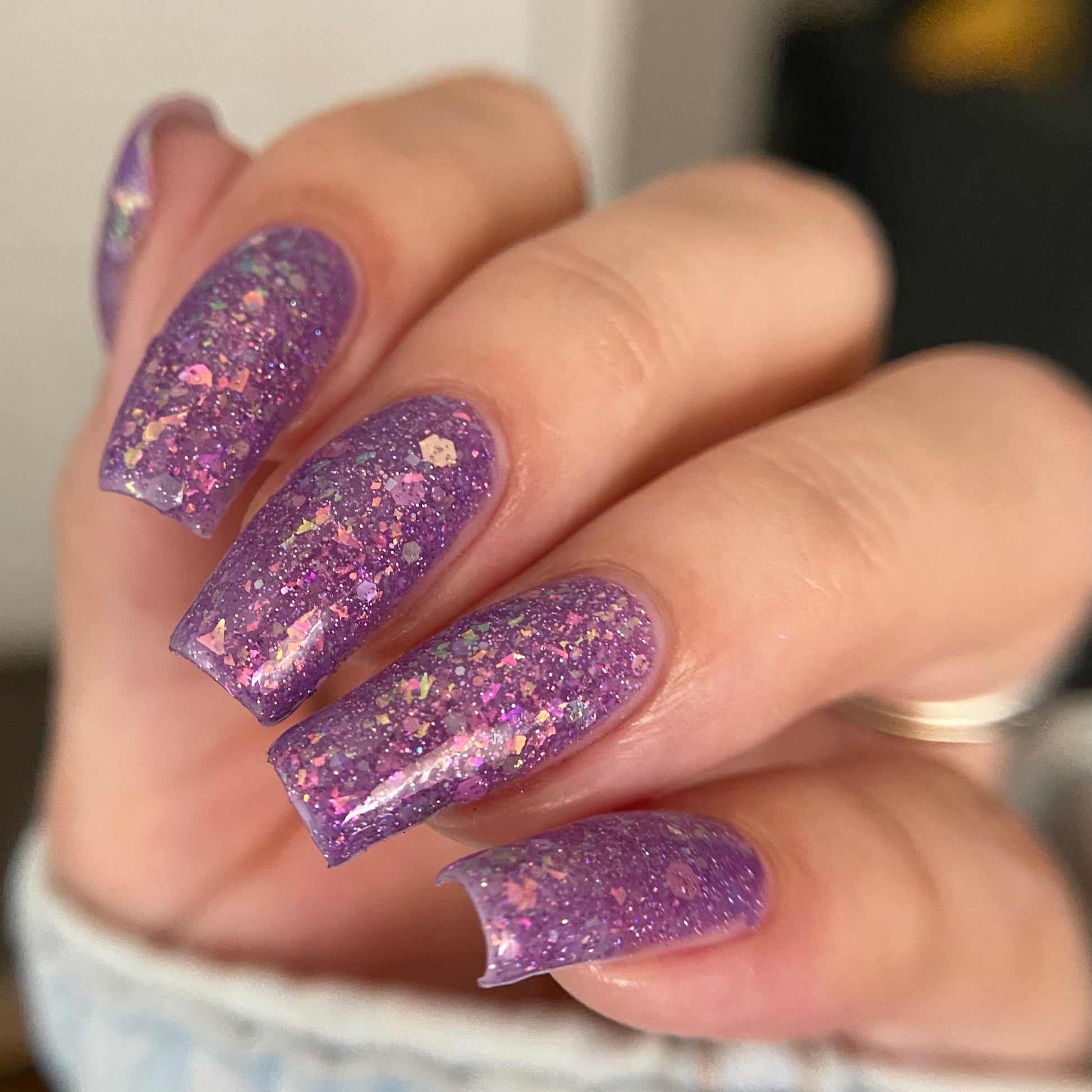Purple nail polish with iridescent rainbow flakies and holo glitter by PI Colors