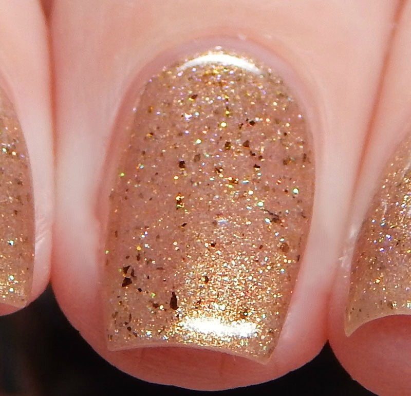 Close-up of three fingernails painted with PI Colors' Golden King.001 Gold Nail Polish. The shimmering polish boasts holographic glitter particles of various sizes, infusing a touch of luxury. The nails are beautifully manicured and evenly coated for a dazzling finish.