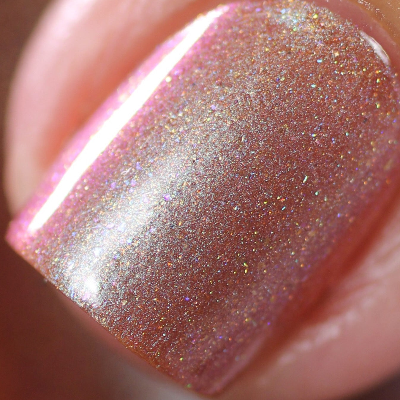 Close-up of a fingernail adorned with Beta Ceti.055 Rust Orange Red nail polish by PI Colors, featuring a captivating holographic glitter that reflects light and casts subtle rainbow hues. This luxury nail lacquer promises a smooth, glossy finish.