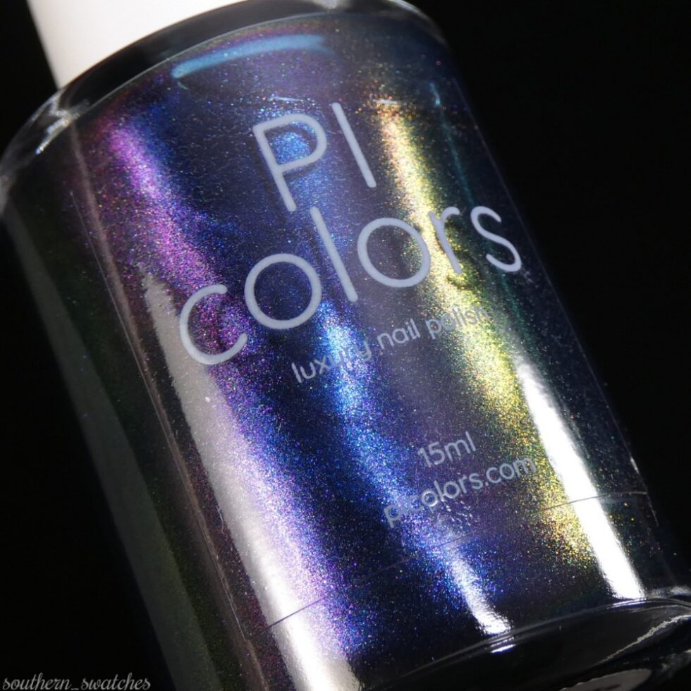 A close-up of a bottle of PI Colors' "Judge None Choose One.000" multichrome nail polish in a 15ml size. The luxury nail lacquer features a vibrant shimmer with shades of blue, purple, pink, and green on a black background.