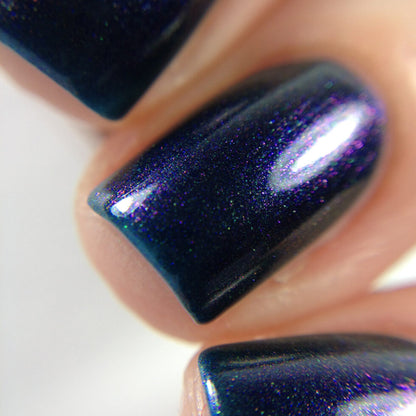 A close-up of fingers adorned with Judge None Choose One.000 by PI Colors, featuring a dark blue glittery nail polish that evokes 90s nostalgia with its glossy finish and subtle purple shimmer. The image highlights the luxurious texture of the nail lacquer, smooth and shiny under bright lighting.