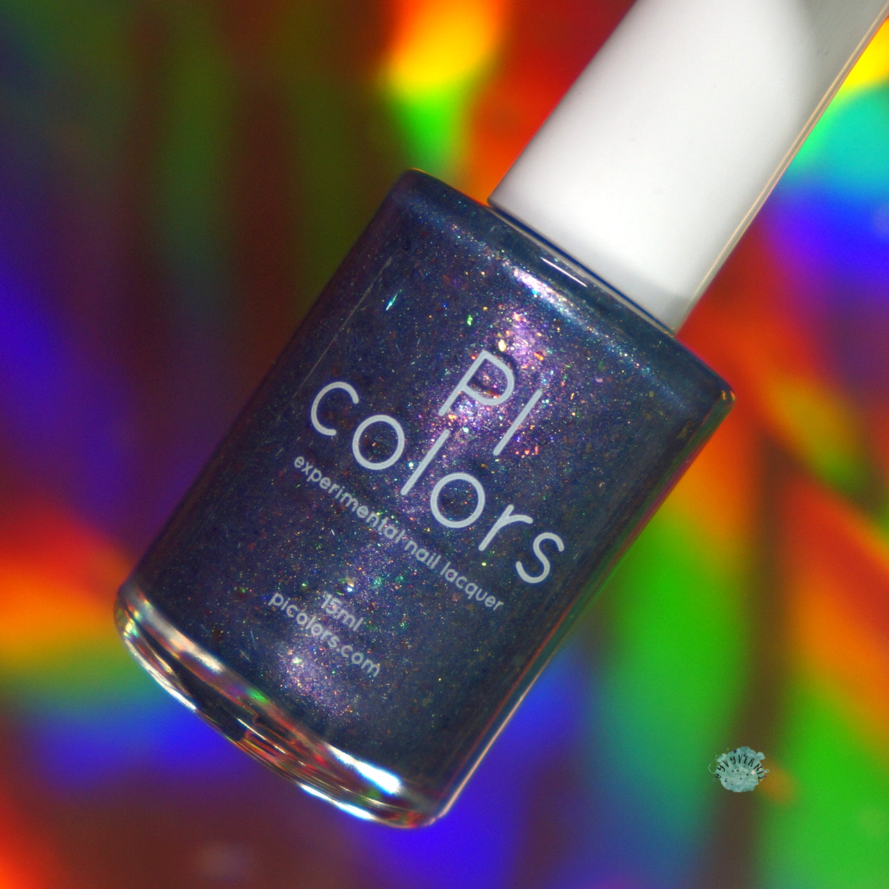 An East of the Storm.029 Blue Nail Polish by PI Colors, boasting a dazzling dark blue shade with a hint of purple, is showcased against a vibrant, multicolored, holographic background. With color-shifting iridescent flakies enhancing its allure, this 15ml "experimenting nail lacquer" bottle shines brilliantly.