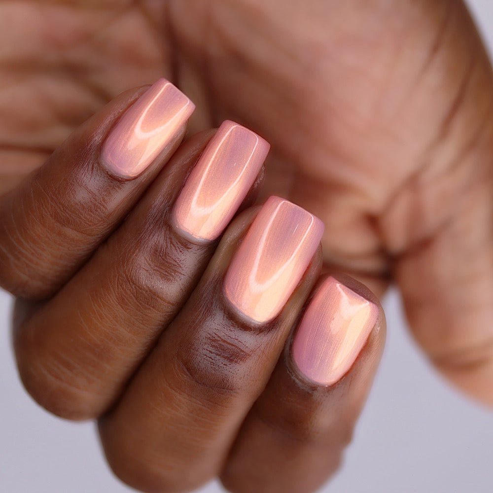 Close-up of a hand with pink nail polish on a neutral background