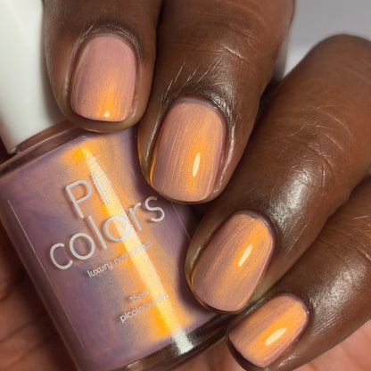 Hand with pink nail polish holding a bottle of 'PI Colors' nail polish.