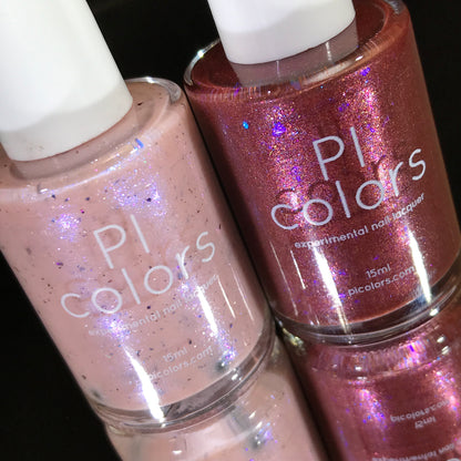 Close-up of two luxurious PI Colors nail polish bottles. The left showcases a light pink with subtle glitter, while the right captivates with "Quasar.156," a shimmery red nail polish boasting a metallic finish. Both prominently display the PI Colors brand name against a stark black background.