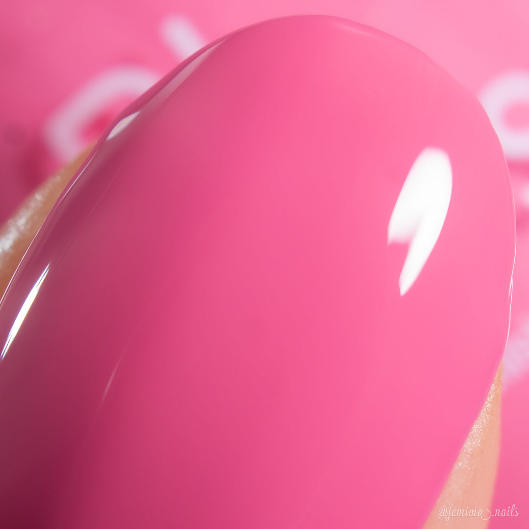 A close-up of a fingernail painted with PI Colors Neapolitan.432, a cool-toned, shiny pink polish that reflects light on its smooth, glossy surface.
