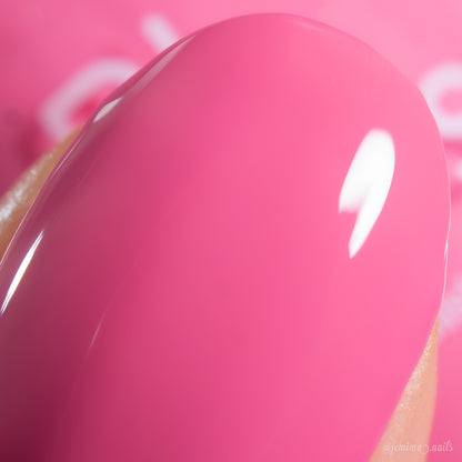 A close-up of a fingernail painted with PI Colors Neapolitan.432, a cool-toned, shiny pink polish that reflects light on its smooth, glossy surface.