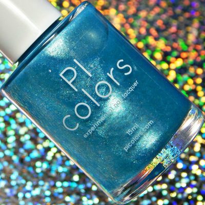 A bottle of Loulaki.101 Blue Nail Polish by PI Colors features a shimmering blue hue accented with iridescent flakies, against a backdrop of vibrant, multicolored holographic effects. The label reads "experimental nail lacquer 15ml picolors.com - Loulaki.101.