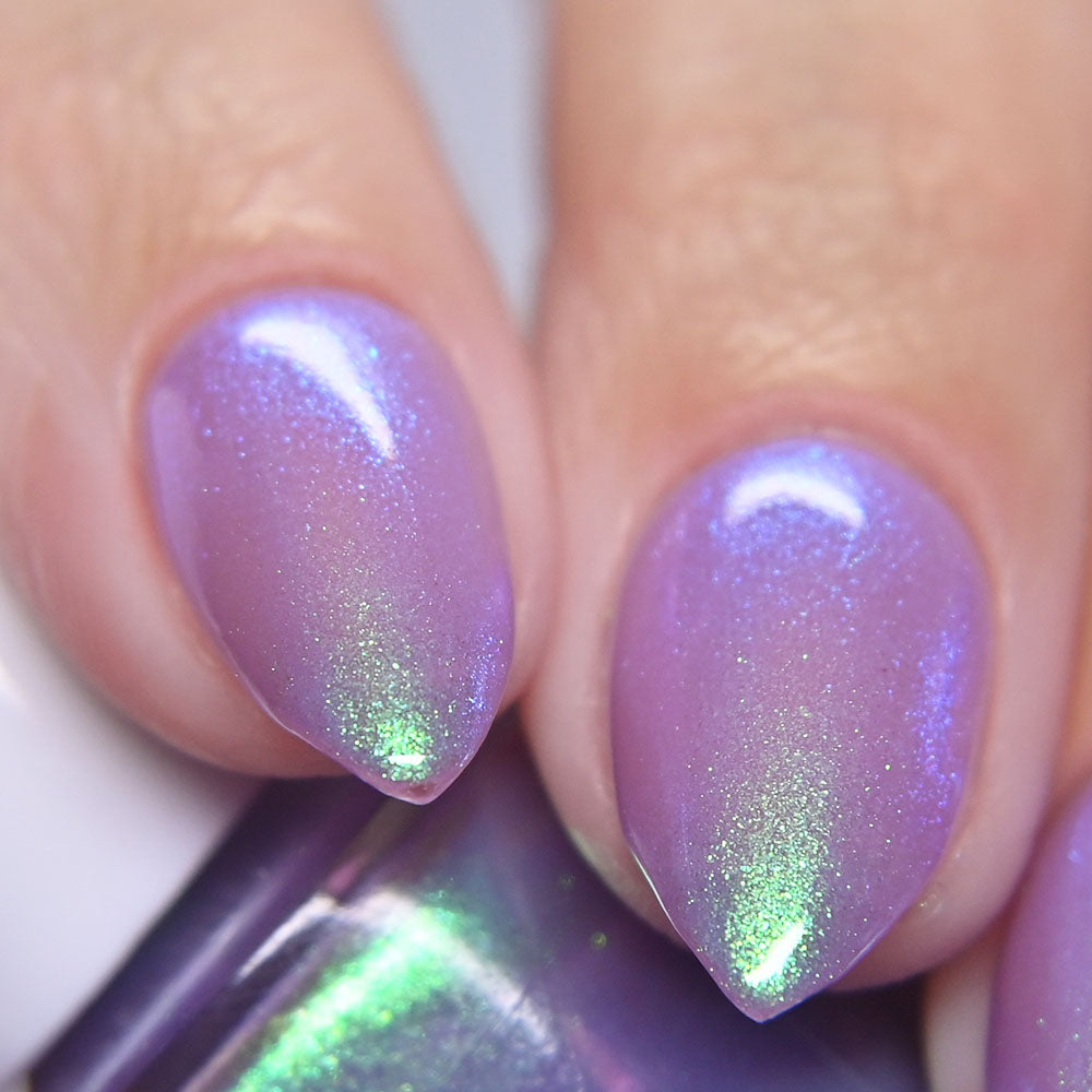 Close-up of nails with purple and green glittery nail polish.