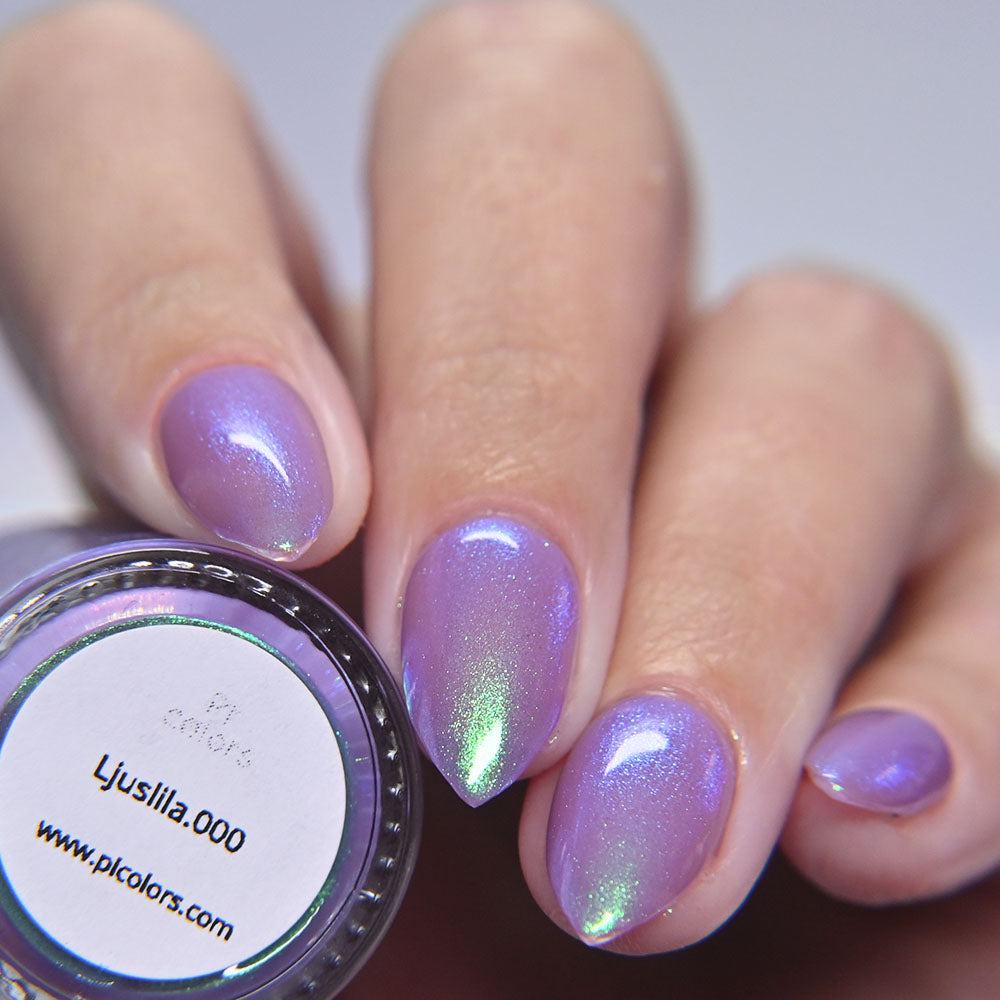 Hand with purple glittery nail polish holding a container of PI colors Ljuslila.000 nail polish.