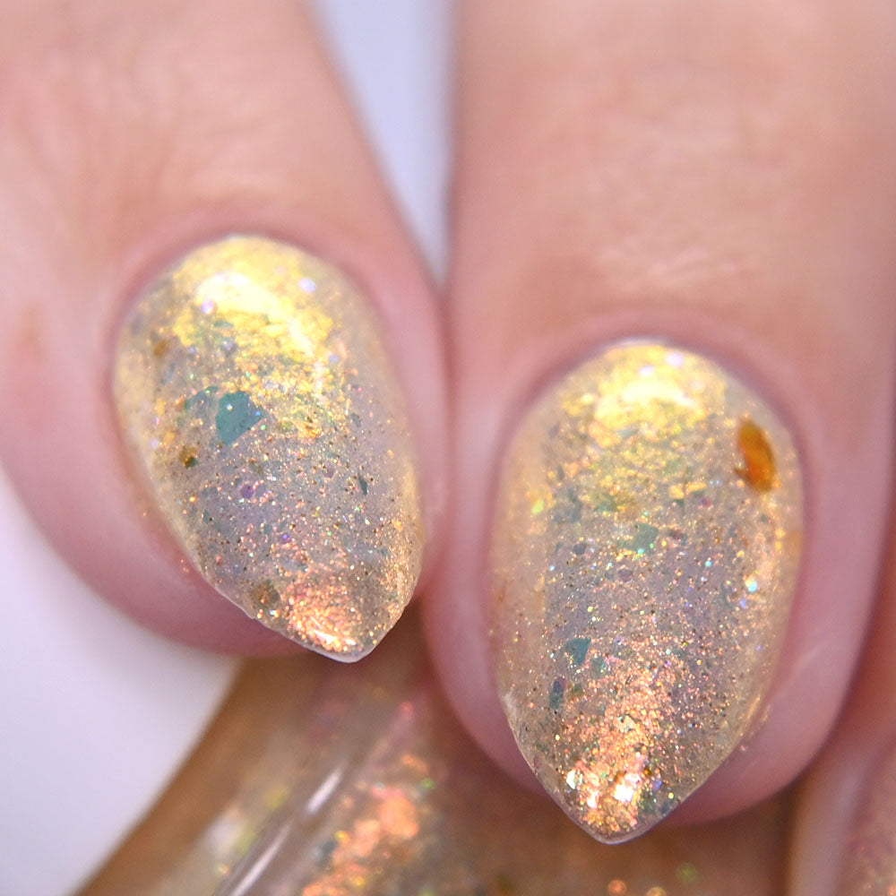 Close-up of nails with glittery gold nail polish on a white background