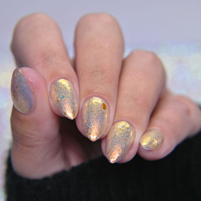 Hand with glittery nail polish on a blurred background