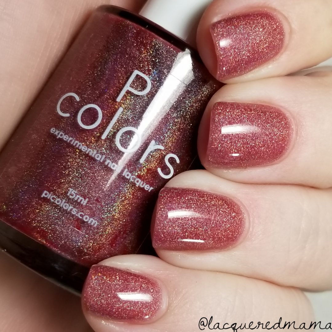 A hand flaunts shimmering red nail polish on short nails, showcasing a linear holo effect. The thumb holds a bottle of "PI Colors Rheum.011 Red Nail Polish," featuring the same glittery polish. The Instagram handle @lacqueredmama appears in the bottom right corner, highlighting their 10-free formula.