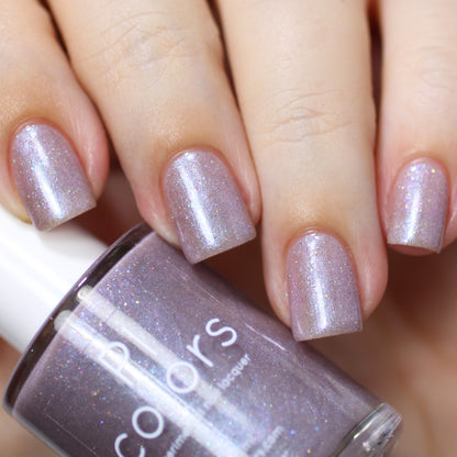 Close-up of three fingers and a thumb showcasing PI Colors' Snow Cherries From France.101 Purple Nail Polish in a glittery lavender hue. A matching bottle of nail polish with holographic glitter is held between the fingers, highlighting its shimmery finish. The neatly manicured nails boast a glossy sheen.