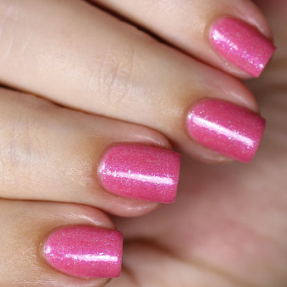 A close-up of a hand with beautifully manicured nails adorned in PI Colors' Strawberry Sundae.002 Pink Nail Polish, enhanced with holographic powder for an eye-catching finish.