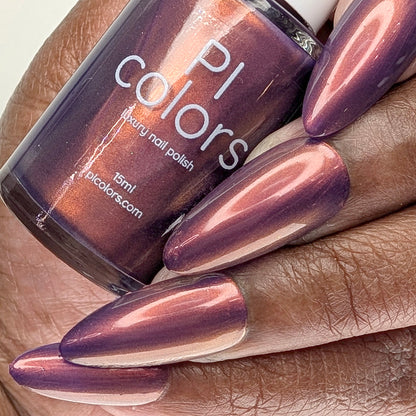 Hand with purple nail polish holding a bottle of PI Colors nail polish.