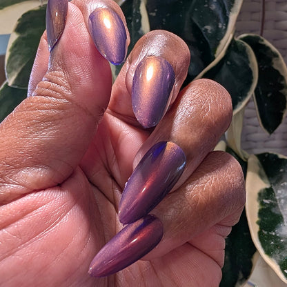 Hand with purple nail polish holding a bottle of PI Colors nail polish.