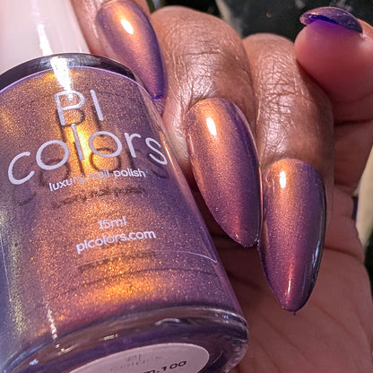 Hand with purple nail polish holding a bottle of PI Colors nail polish.