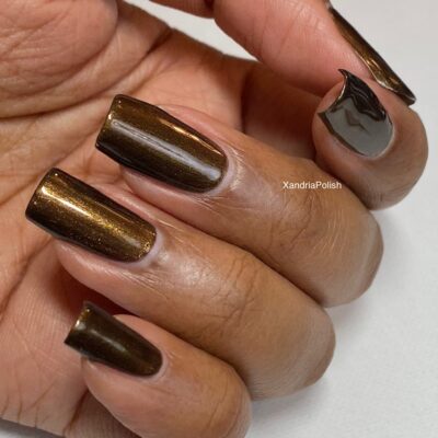 A hand features long, square-shaped nails adorned with PI Colors' Eclair.001 Brown Nail Polish, presenting a glossy dark chocolate brown hue. The ring finger showcases a sophisticated black wave design, while the luxurious polish lends a shiny finish to the visible thumb.