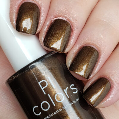A close-up of hands with short, square-shaped nails showcases a rich, dark chocolate brown shimmer. Nestled between the fingers is a matching bottle of handmade PI Colors nail polish labeled "Éclair.001 Brown Nail Polish," highlighting the luxurious brand and color.