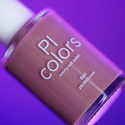 A bottle of PI Colors Iced Oatmeal.478 luxury handmade nail polish (15ml) is shown against a vibrant purple background, with the label displaying the brand name, product type, volume, and website.