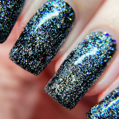 Close-up of fingernails painted with luxury PI Colors nail lacquers, featuring a mesmerizing combination of black and Diamond Blast.401 Silver Holographic Glitter Nail Polish Topper, creating a sparkling, textured effect. The nails are neatly manicured, showcasing the glossy and eye-catching design.