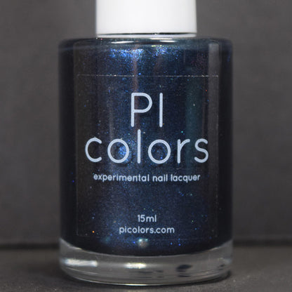 A bottle of Midnight Bloom.022 Blue Black Nail Polish by PI Colors is pictured, featuring a deep blue shade with a captivating blue shimmer. The label prominently displays the PI Colors brand name and website. Gleaming softly, the bottle is set against a dark background.