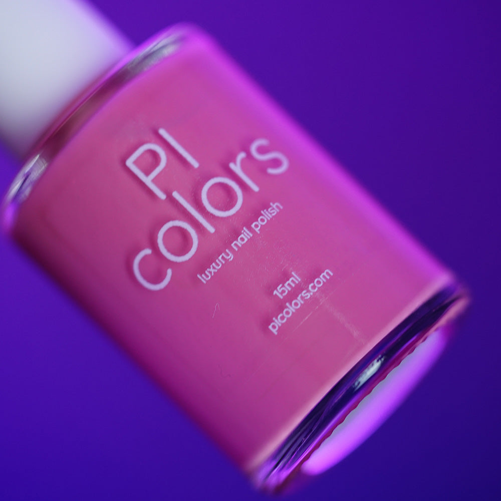 A close-up of a pink handmade nail polish bottle labeled "PI Colors Neapolitan.432, 15 ml" against a purple background.