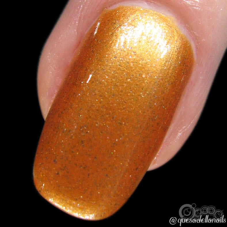 A close-up of a fingernail adorned with Pirate Booty.017 from PI Colors reveals a glossy metallic orange hue with a smooth and shiny finish, beautifully enhanced by holographic glitter. The surrounding skin is visible around the nail.