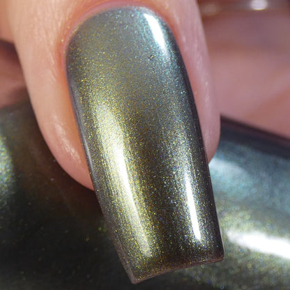 Close-up of a fingernail painted with PI Colors' Light/Forest.000 Green Nail Polish, showcasing a smooth, glossy finish with specks of gold shimmer. The skin around the nail is slightly visible.