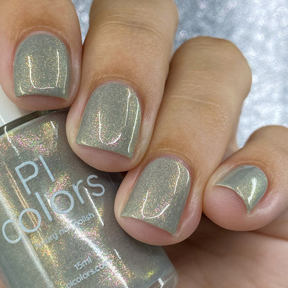 Close-up of fingers adorned with shiny gray nail polish, featuring a bottle labeled "PI Colors." The nails exhibit a subtle holographic sheen, evocative of the ToW.001 Taupe Nail Polish's shimmering aurora lacquer.
