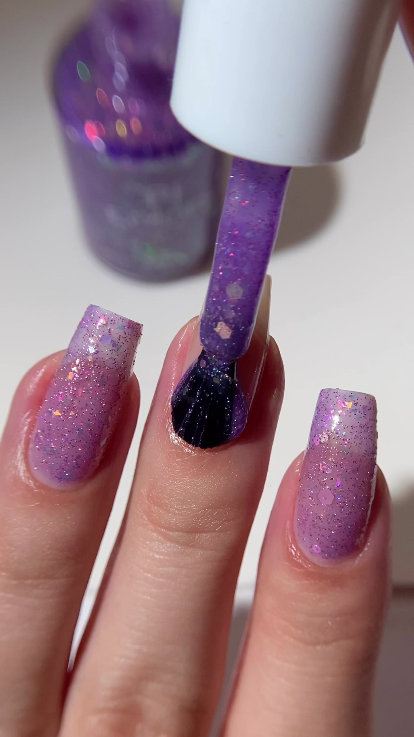 Purple nail polish with iridescent rainbow flakies and holo glitter by PI Colors