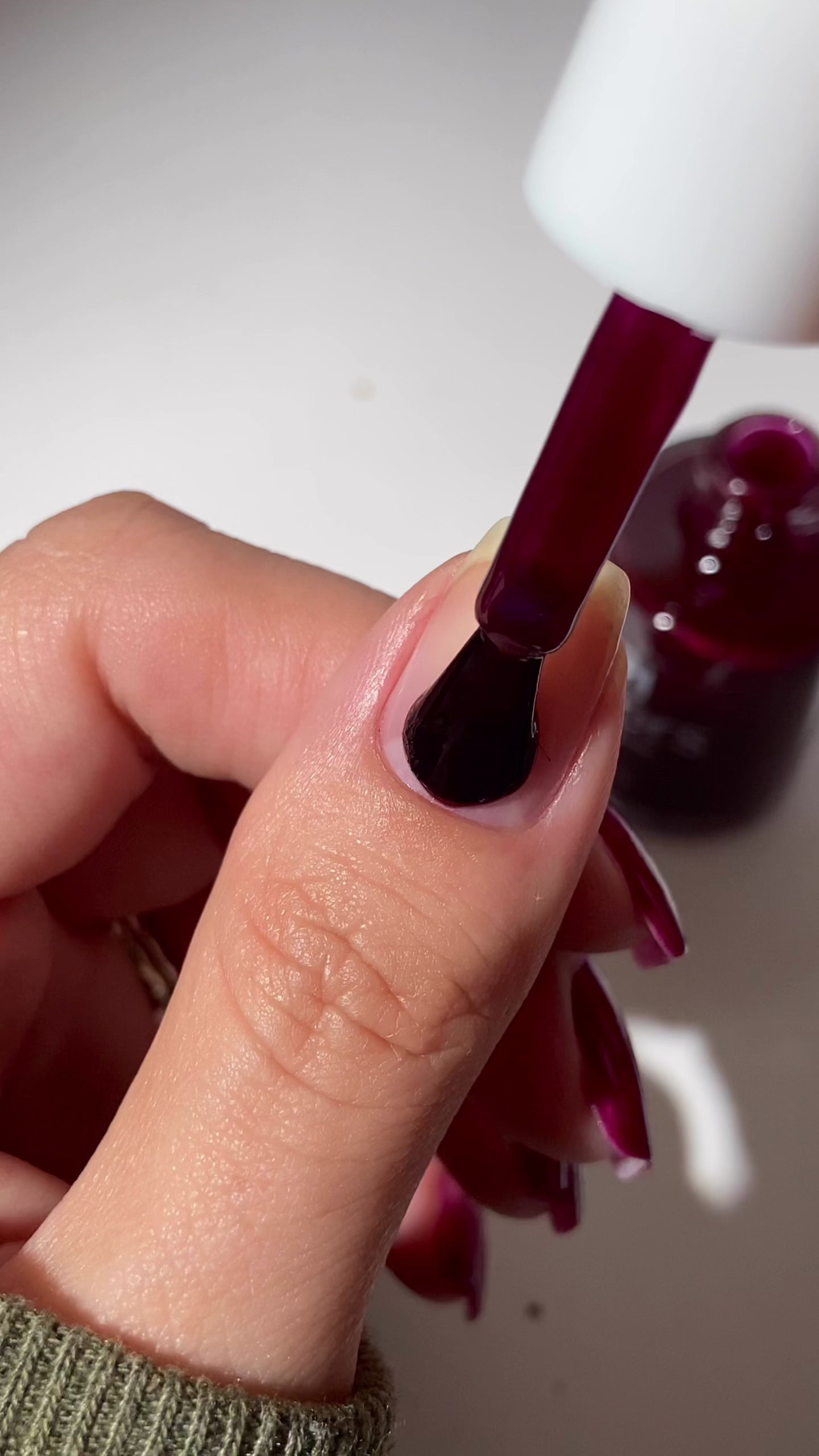 Video of red burgundy nail polish being applied to natural nail