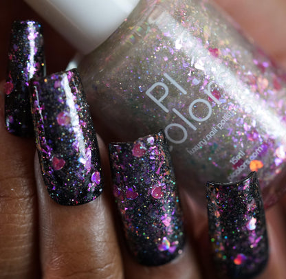 A hand showcasing long nails painted in sparkly dark polish with pink and purple glitter accents holds a bottle of PI Colors' Stormy Hearts.206, featuring holographic hearts and an enchanting silver holo glitter ensemble.